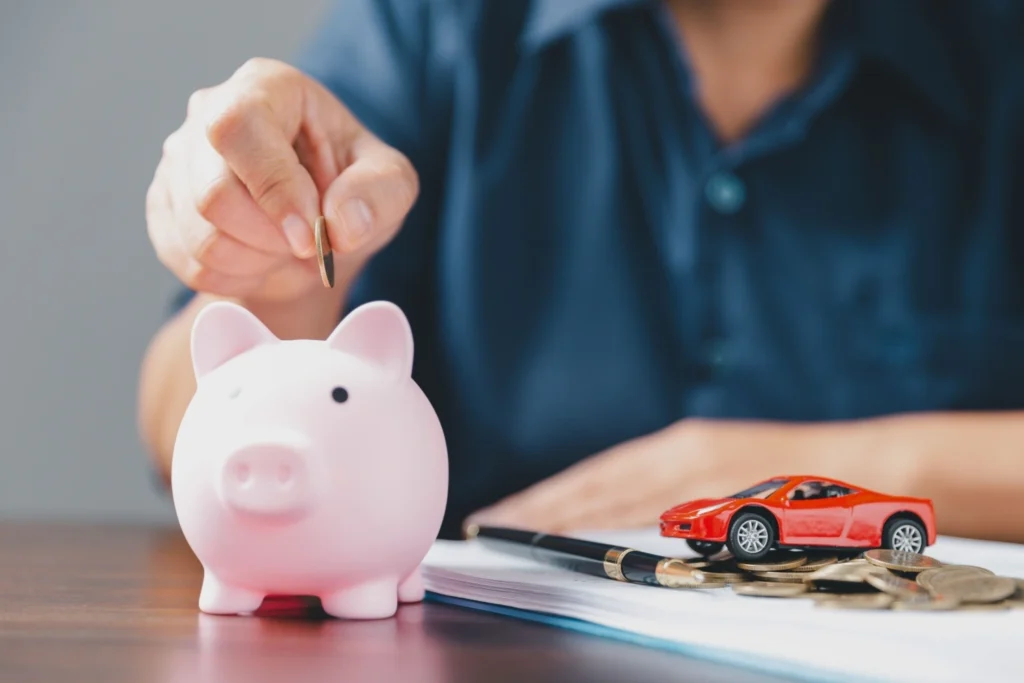 salvadanaio nel quale viene inserita una moneta come metafora del pagamento del bollo dell'auto a noleggio a lungo termine